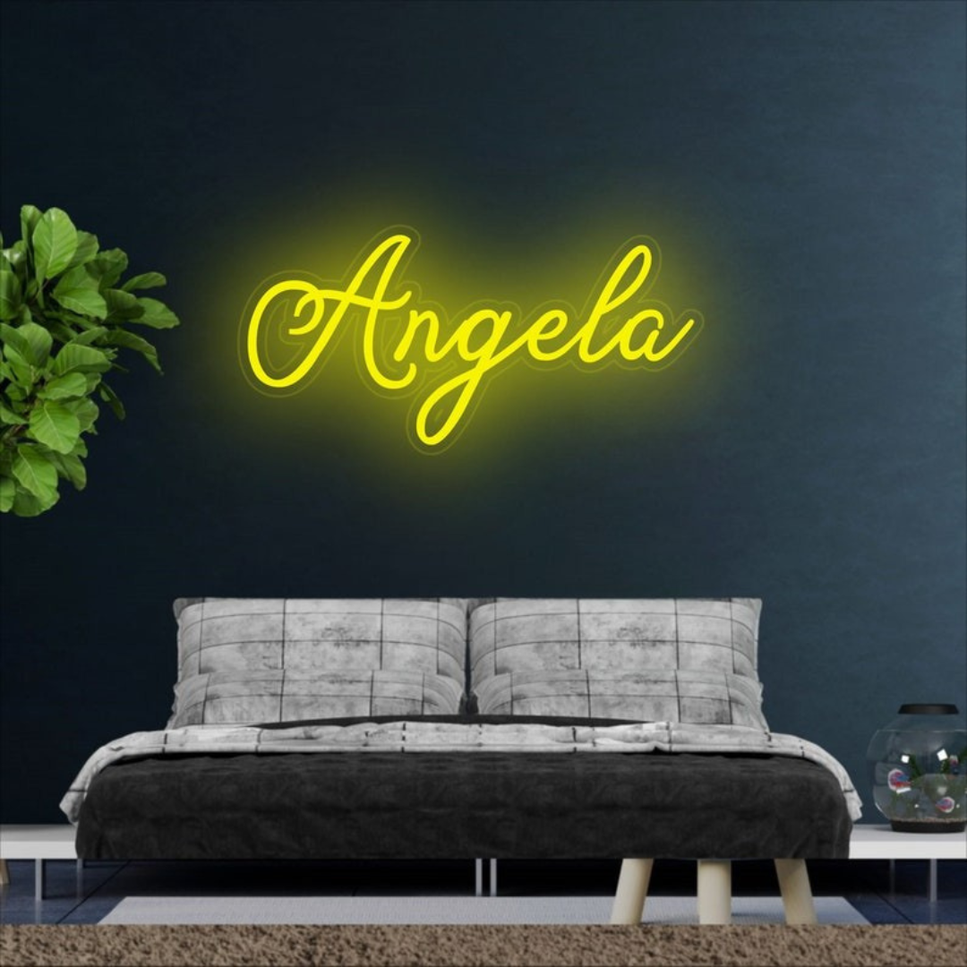 Angela Name Neon sign by Neon.Outshine  - in glowing cursive, mounted on clear acrylic and illuminating a chic, modern space with vibrant light.