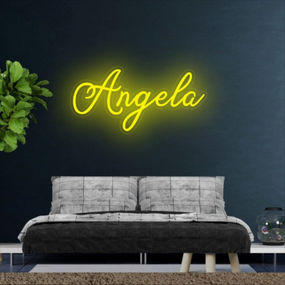 Angela Name Neon sign by Neon.Outshine  - in glowing cursive, mounted on clear acrylic and illuminating a chic, modern space with vibrant light.