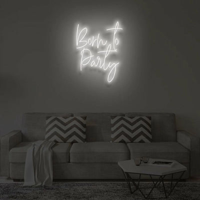 Born To Party LED neon sign glowing in vibrant colors, mounted on a wall in a party setting - Neon.Outshine 