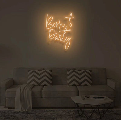 Born To Party LED neon sign glowing in vibrant colors, mounted on a wall in a party setting - Neon.Outshine 