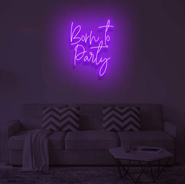 Born To Party LED neon sign glowing in vibrant colors, mounted on a wall in a party setting - Neon.Outshine 