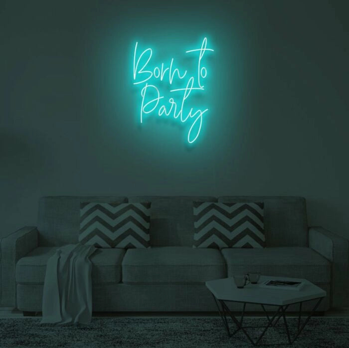 Born To Party LED neon sign glowing in vibrant colors, mounted on a wall in a party setting - Neon.Outshine 