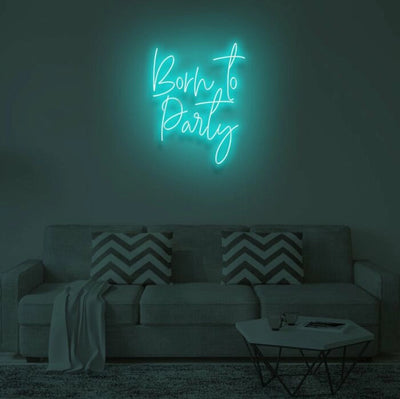 Born To Party LED neon sign glowing in vibrant colors, mounted on a wall in a party setting - Neon.Outshine 