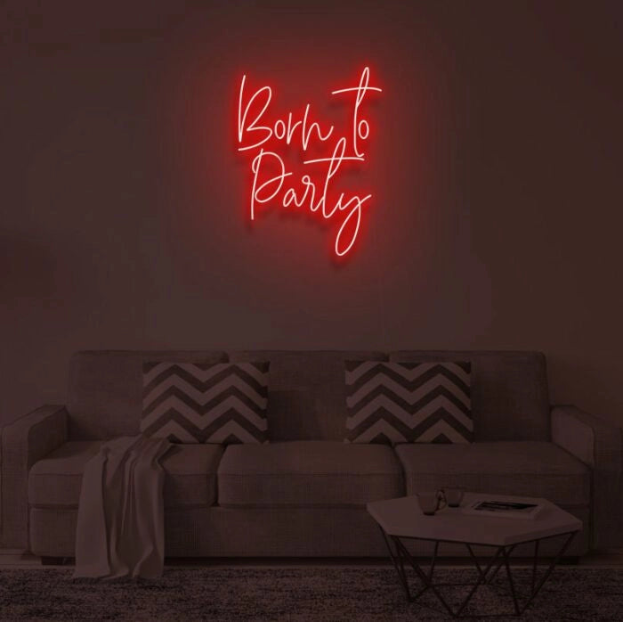 Born To Party LED neon sign glowing in vibrant colors, mounted on a wall in a party setting - Neon.Outshine 
