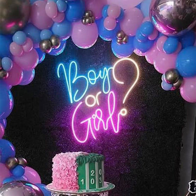 Boy or Girl? neon sign in blue and pink by Neon.Outshine, mounted on a clear acrylic backdrop with baby shower decorations