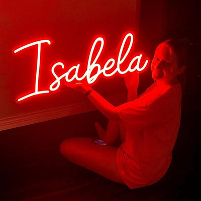 Isabella Name Neon sign By Neon.Outshine - in elegant script, casting a soft pink light on a bedroom wall.