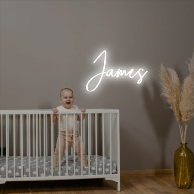 James Name neon sign above a child’s bed in a softly lit nursery - Neon.Outshine 