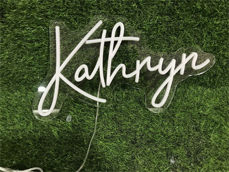 ‘Katheryn’ neon name sign glowing above a bed in a modern bedroom - Neon.Outshine 