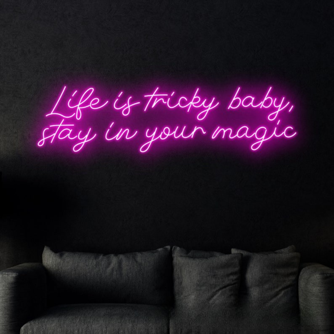 ‘Life is Tricky Baby, Stay in Your Magic Neon sign in bright pink, glowing on a dark wall – handcrafted by Neon.Outshine.