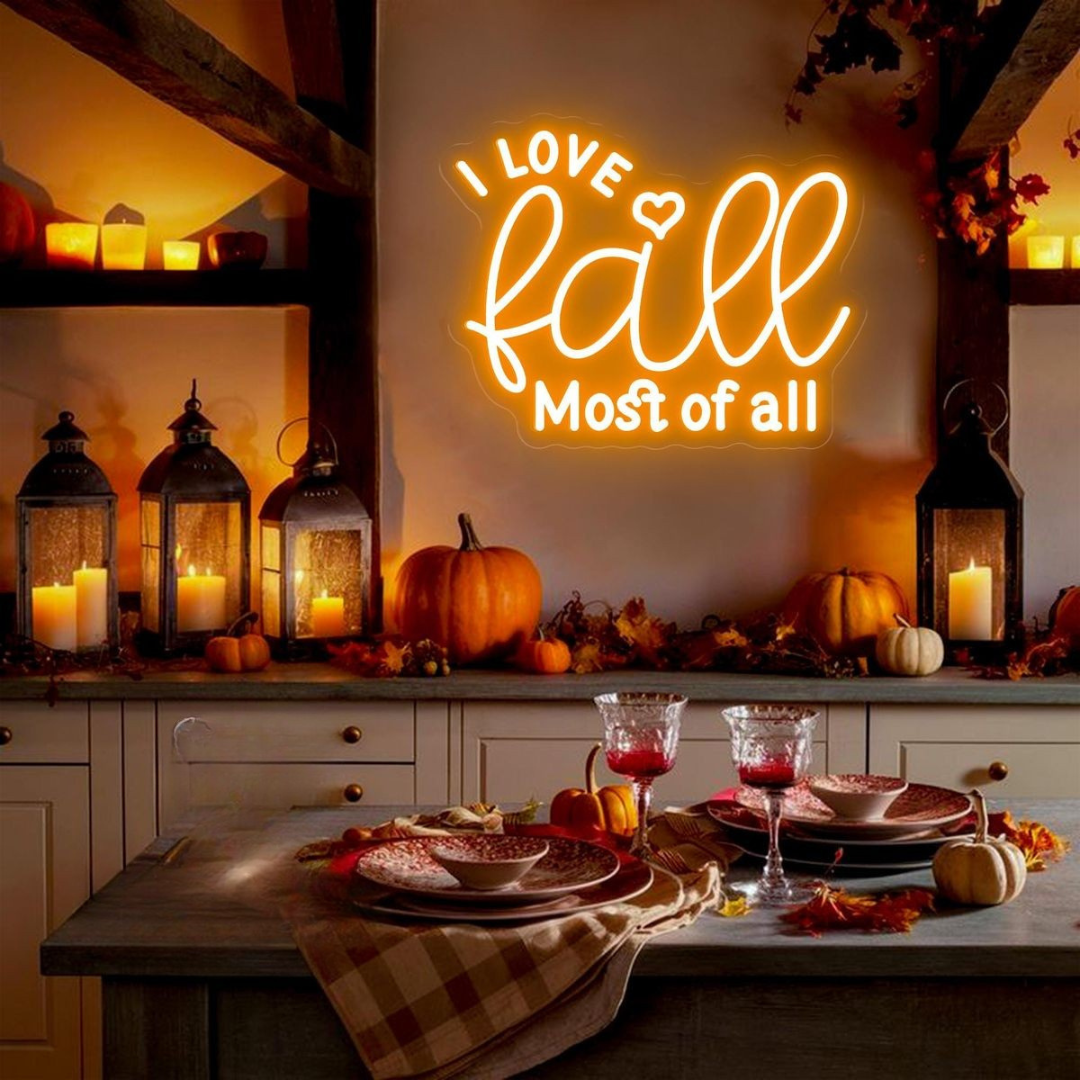 Love Fall Most of All neon sign in glowing on clear acrylic backing by Neon.outshine, set in cozy autumn decor setting.