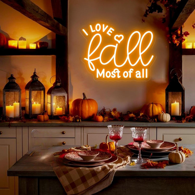 Love Fall Most of All neon sign in glowing on clear acrylic backing by Neon.outshine, set in cozy autumn decor setting.