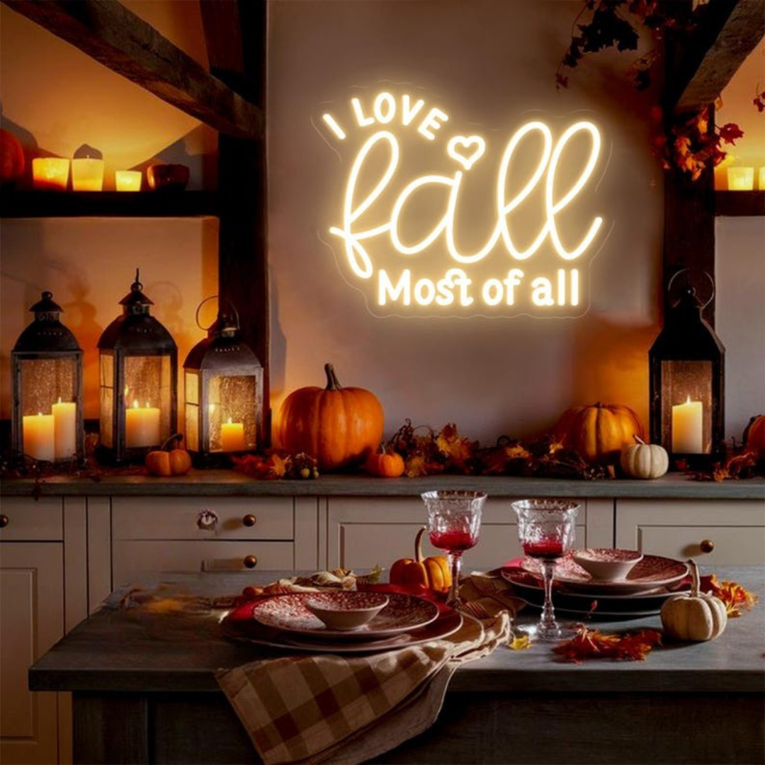 Love Fall Most of All neon sign in glowing on clear acrylic backing by Neon.outshine, set in cozy autumn decor setting.