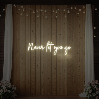 Never Let You Go Wedding Neon Sign by Neon.Outshine glowing beautifully behind a romantic wedding reception setup.
