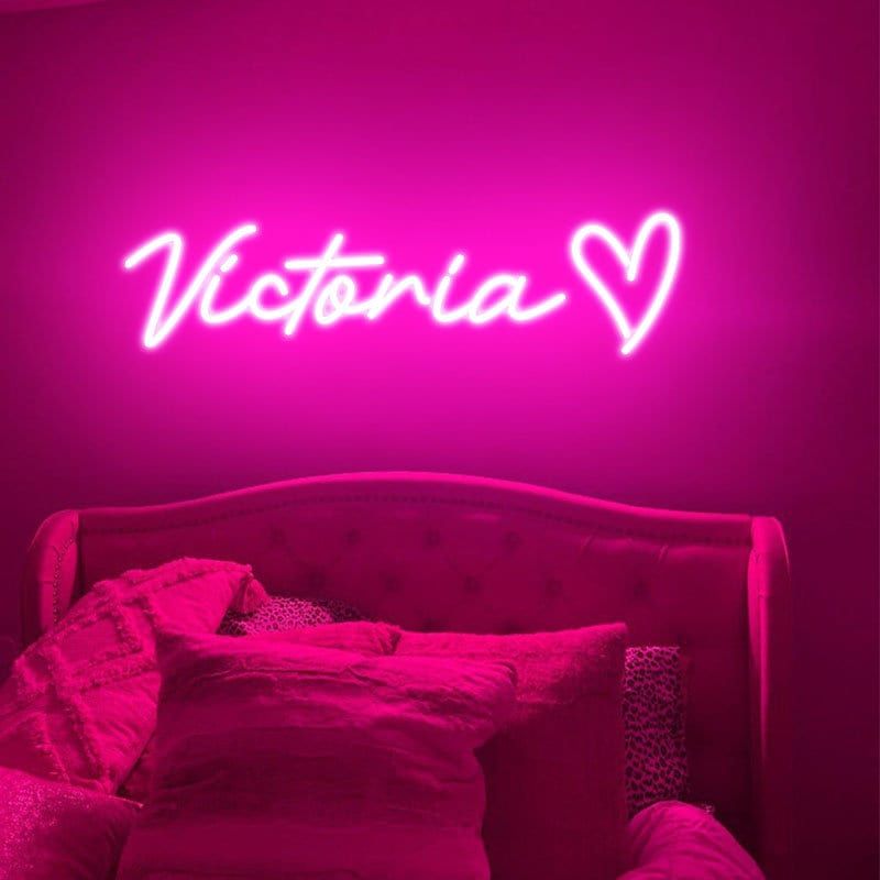 Victoria Name Neon sign by Neon.Outshine - mounted on a clear acrylic backing and softly illuminating a modern interior wall.