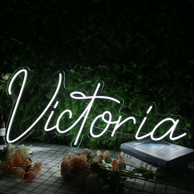 Victoria Name Neon sign by Neon.Outshine - mounted on a clear acrylic backing and softly illuminating a modern interior wall.