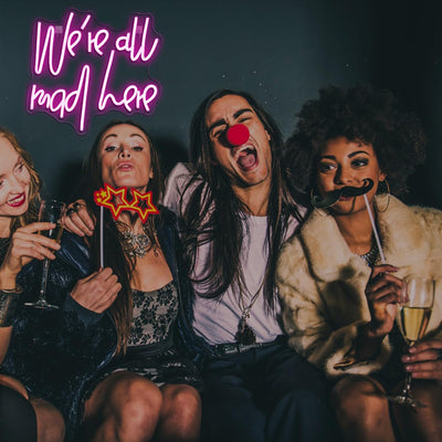 We’re All Mad Here LED neon sign glowing in bright colors on a wall at a party by Neon.Outshine 