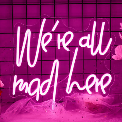 We’re All Mad Here LED neon sign glowing in bright colors on a wall at a party by Neon.Outshine 