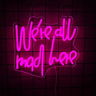 We’re All Mad Here LED neon sign glowing in bright colors on a wall at a party by Neon.Outshine 