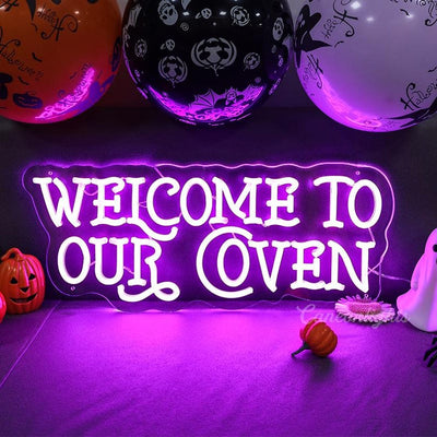 Welcome to Our Coven Halloween neon sign in glowing purple on clear acrylic backing by Neon.outshine, displayed in dark spooky room."